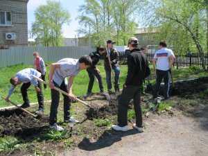 Школьники помогают вскопать грядки для посадки цветов